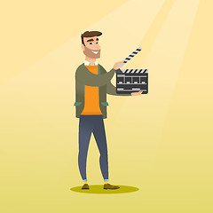 Image showing Smiling man holding an open clapperboard.