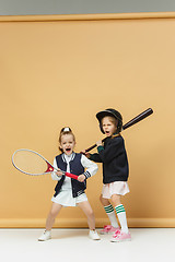 Image showing Portrait of two girls as tennis players holding tennis racket. Studio shot.