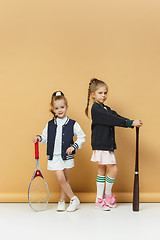 Image showing Portrait of two girls as tennis players holding tennis racket. Studio shot.