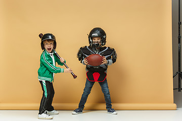 Image showing Two happy children show different sport. Studio fashion concept. Emotions concept.