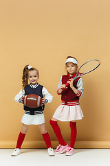 Image showing Two happy and beautyful children show different sport. Studio fashion concept. Emotions concept.