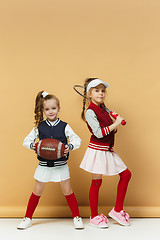 Image showing Two happy and beautyful children show different sport. Studio fashion concept. Emotions concept.