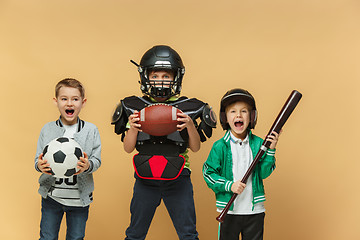 Image showing Three happy children show different sport. Studio fashion concept. Emotions concept.