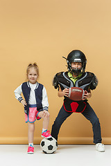 Image showing Two happy and beautyful children show different sport. Studio fashion concept. Emotions concept.