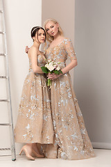 Image showing Brides in beautiful dress standing indoors in white studio interior like at home. Trendy wedding style shot. Young attractive caucasian model like a bride tender looking.