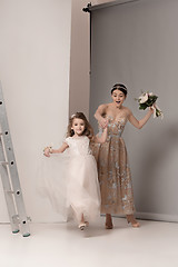 Image showing Little pretty girls with flowers dressed in wedding dresses