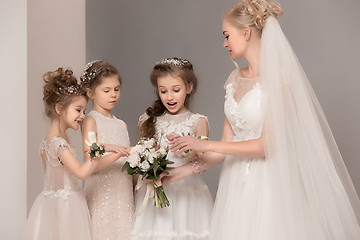 Image showing Little pretty girls with flowers dressed in wedding dresses