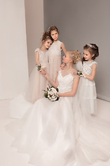 Image showing Little pretty girls with flowers dressed in wedding dresses