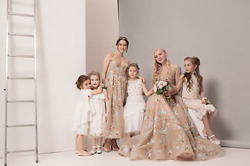 Image showing Little pretty girls with flowers dressed in wedding dresses