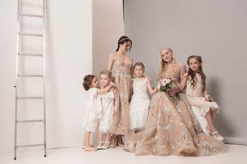 Image showing Little pretty girls with flowers dressed in wedding dresses