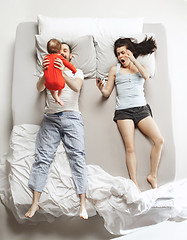 Image showing Top view of happy family with one newborn child in bedroom.