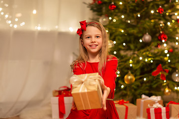 Image showing smiling girl with christmas gift at home