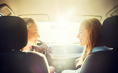 Image showing happy teenage girls or women in car at seaside