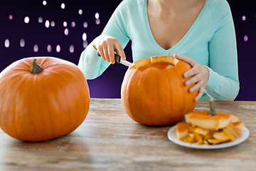 Image showing close up of woman carving halloween pumpkin