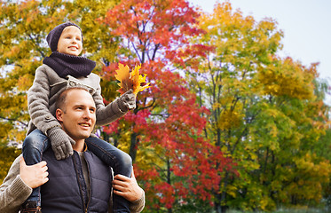 Image showing happy father carrying son with autumn maple leaves