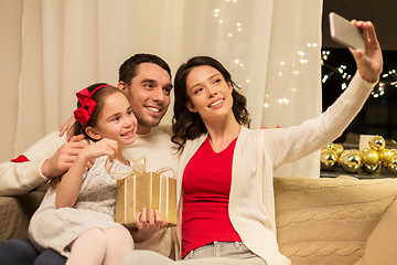 Image showing happy family with christmas present at home