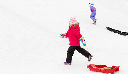 Image showing little girl with sleds on snow hill in winter