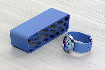 Image showing Smart watch and wireless speaker on wood table