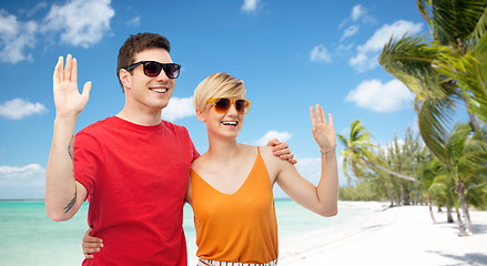 Image showing couple in sunglasses hugging and waving hands