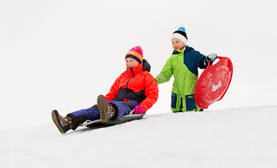 Image showing kids sliding on sleds down snow hill in winter