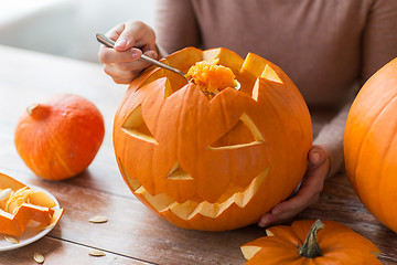 Image showing close up of woman carving halloween pumpkin