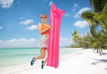 Image showing teenage girl jumping with float mattress on beach