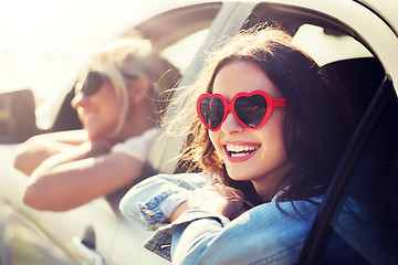 Image showing happy teenage girls or women in car at seaside