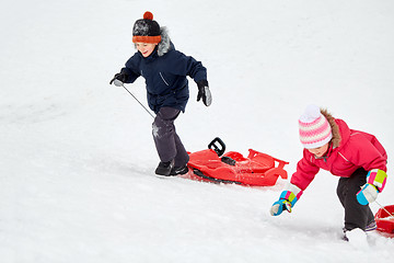 Image showing kids with sleds climbing snow hill in winter