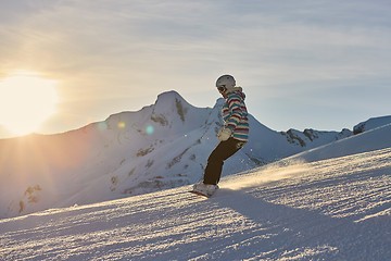 Image showing Female snowboarder in sun flare