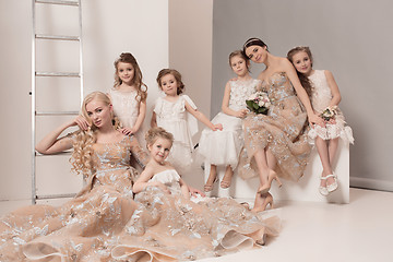 Image showing Little pretty girls with flowers dressed in wedding dresses