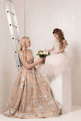 Image showing Little pretty girls with flowers dressed in wedding dresses