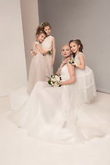 Image showing Little pretty girls with flowers dressed in wedding dresses