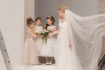 Image showing Little pretty girls with flowers dressed in wedding dresses