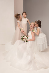 Image showing Little pretty girls with flowers dressed in wedding dresses