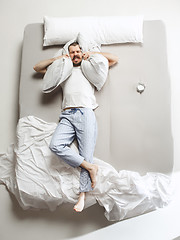 Image showing Top view photo of young man sleeping in a big white bed