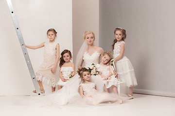 Image showing Little pretty girls with flowers dressed in wedding dresses