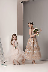 Image showing Little pretty girls with flowers dressed in wedding dresses