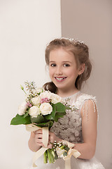 Image showing Little pretty girl with flowers dressed in wedding dresses