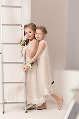 Image showing Little pretty girls with flowers dressed in wedding dresses