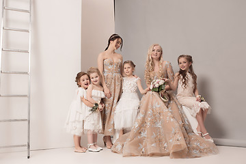 Image showing Little pretty girls with flowers dressed in wedding dresses