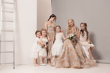 Image showing Little pretty girls with flowers dressed in wedding dresses