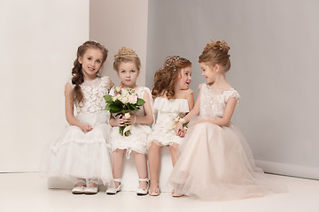 Image showing Little pretty girls with flowers dressed in wedding dresses