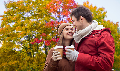 Image showing happy couple with coffee walking in autumn park