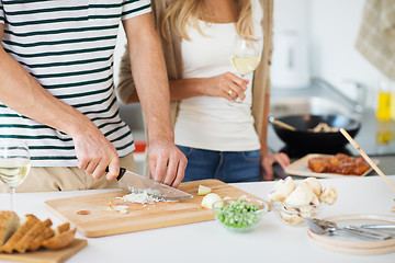 Image showing couple cooking food and drinking wine at home