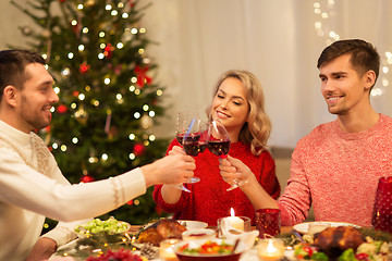 Image showing happy friends drinking red wine at christmas party