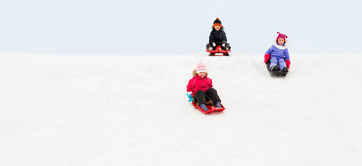 Image showing kids sliding on sleds down snow hill in winter