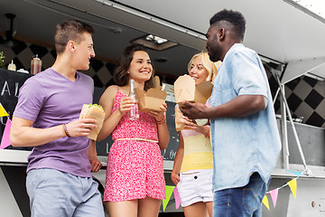 Image showing happy friends with drinks eating at food truck