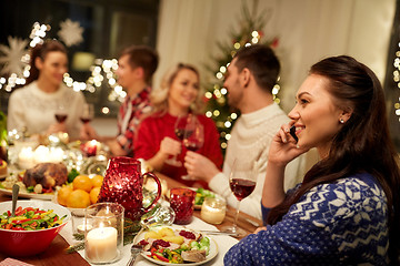 Image showing woman calling on smartphone at christmas dinner