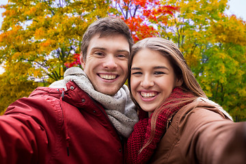 Image showing happy couple taking selfie in autumn