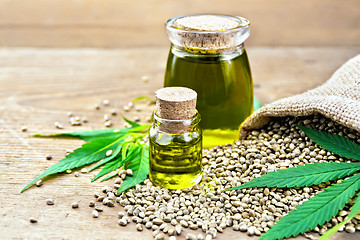 Image showing Oil hemp in two jars with grain on board